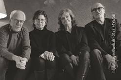 Ein Bild, das vier Personen sitzend zeigt.